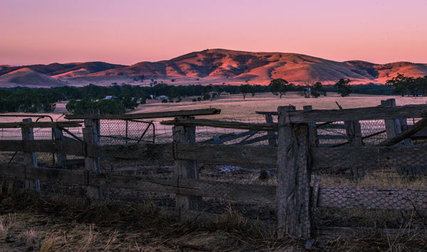 Broken fence and outback hills